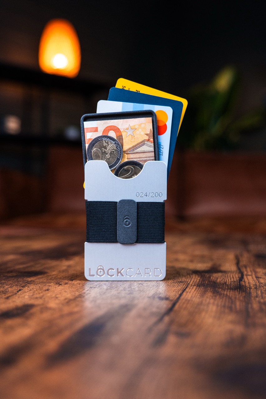 Das Lockcard Mono auf einem Tisch mit Cashslider leicht rausgeschoben und gefächerten Karten